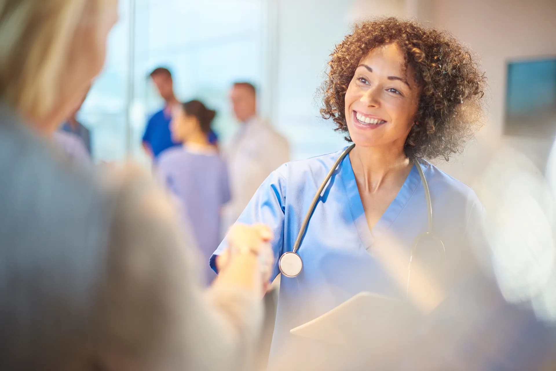 Pflegefachkraft begrüßt eine Patientin — willkommen im deutschen Gesundheitswesen